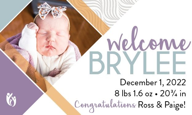 Announcement card with a photo of newborn Brylee wearing a headband. Text: “Welcome Brylee, 12-1-22, 8 lbs 1.6 oz, 20¾ in. Congratulations Ross & Paige!” Decorative pastel accents and logo.