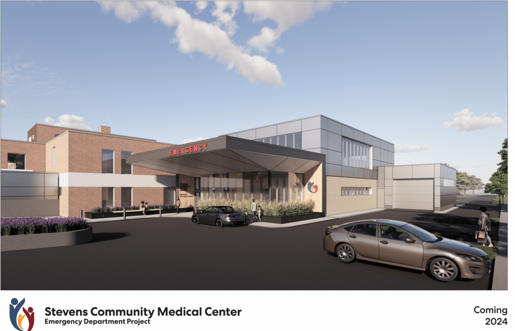 Rendering of Stevens Community Medical Center’s future Emergency Department entrance highlights the groundbreaking ER expansion, with cars parked outside, modern glass and brick design, and signage. Text reads “Coming 2024.” Blue sky with clouds overhead.