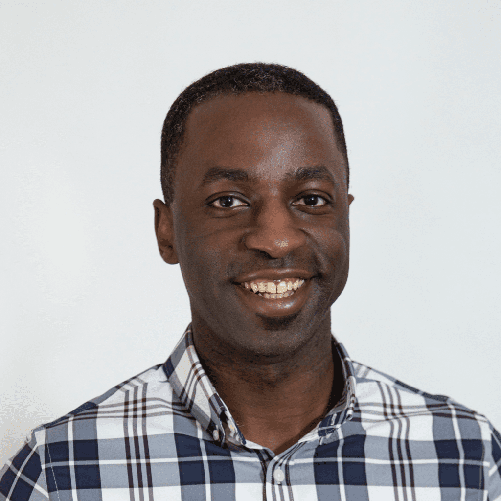 A man wearing a blue and white plaid shirt smiles at the camera against a plain white background, introducing himself as Darrin J. Spoden, DO.